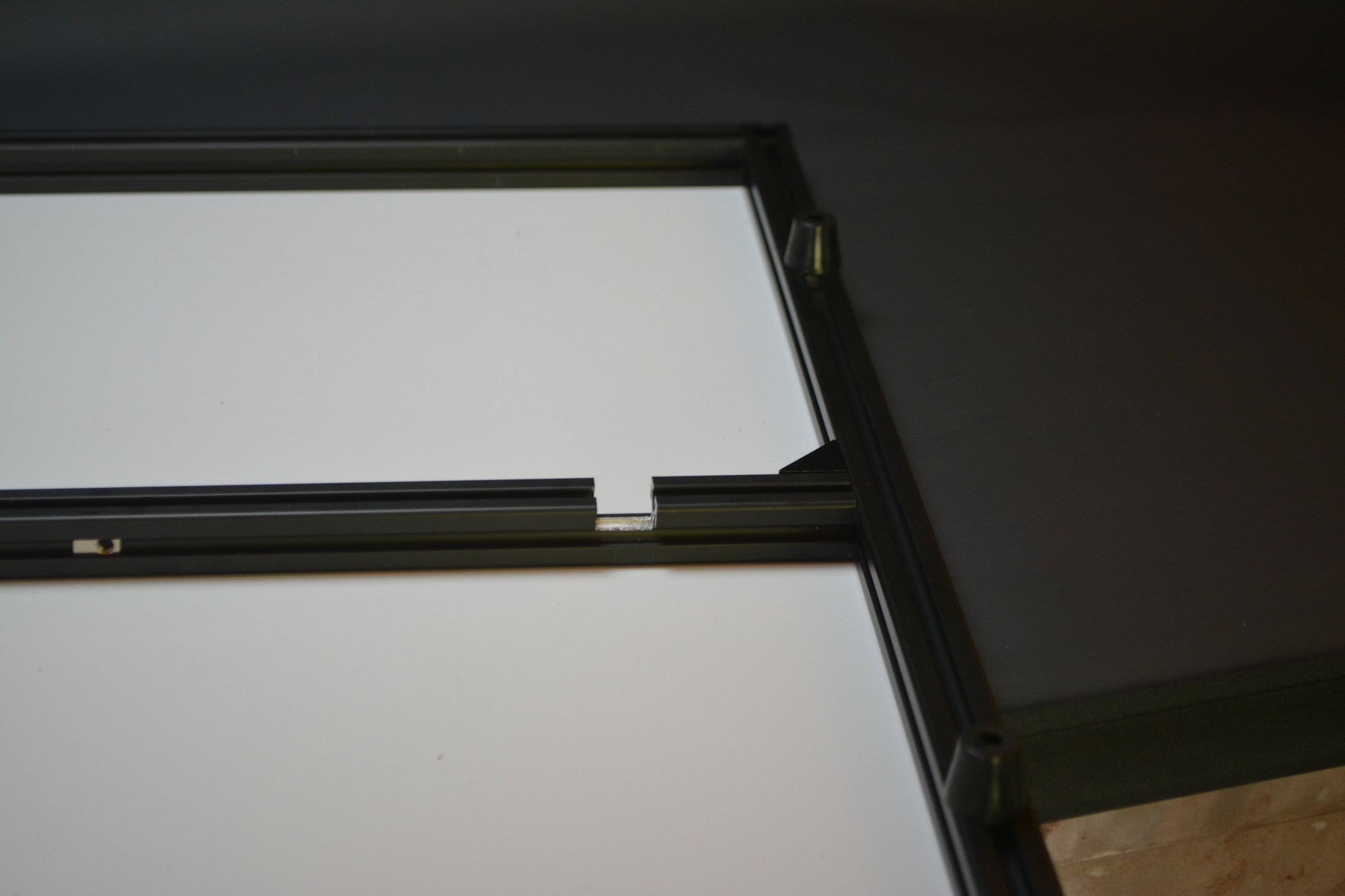 A slot cut in the lip of the frame cross-member